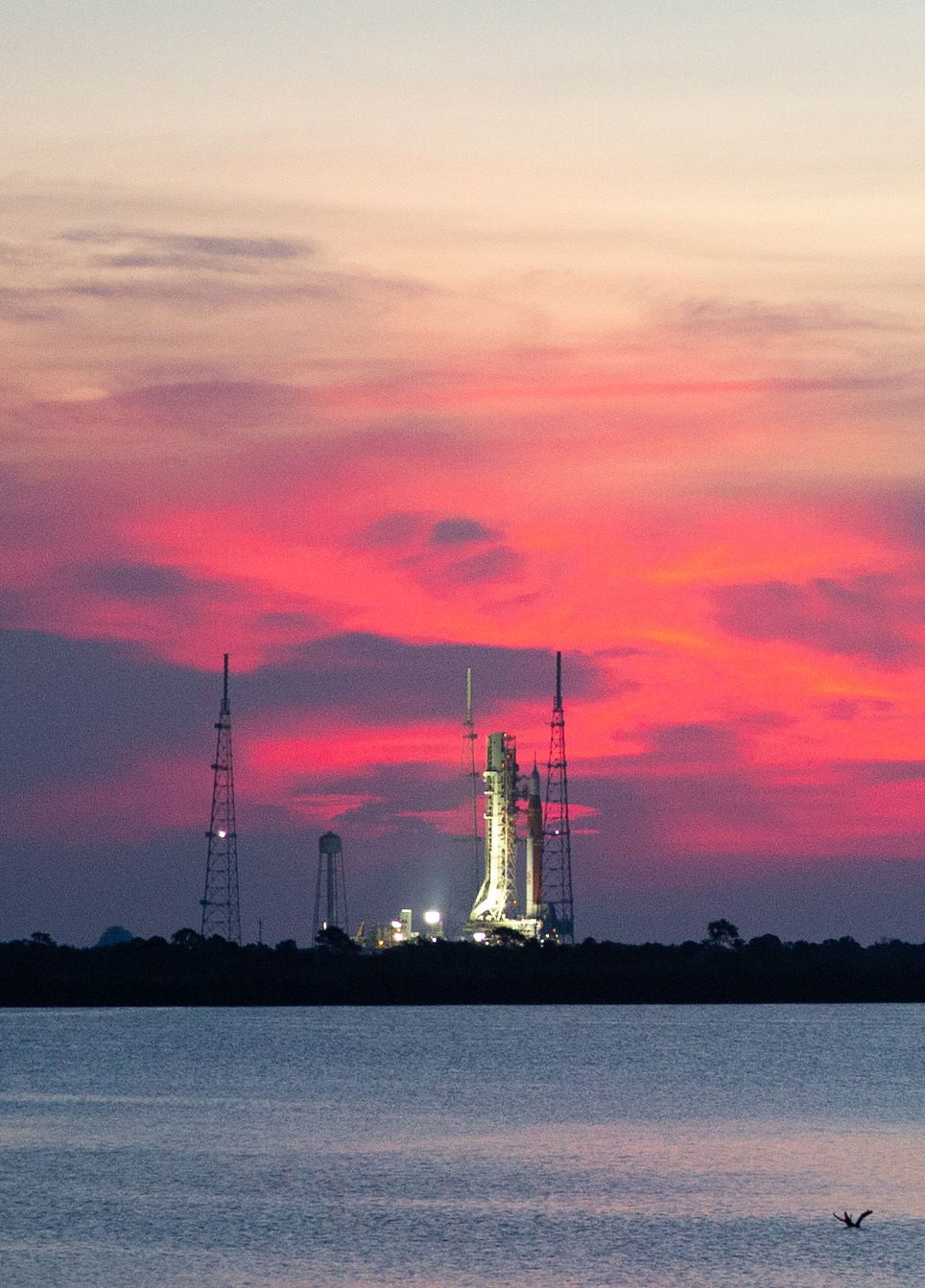 rocket on launch pad with red sunset in background
