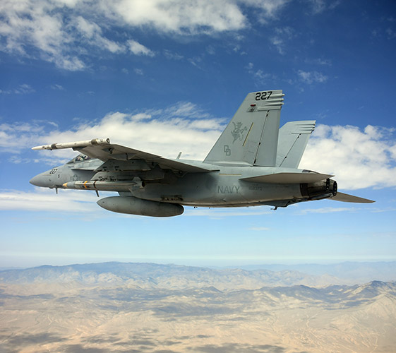 A U.S. Navy F/A-18 Super Hornet carring a missile inflight
