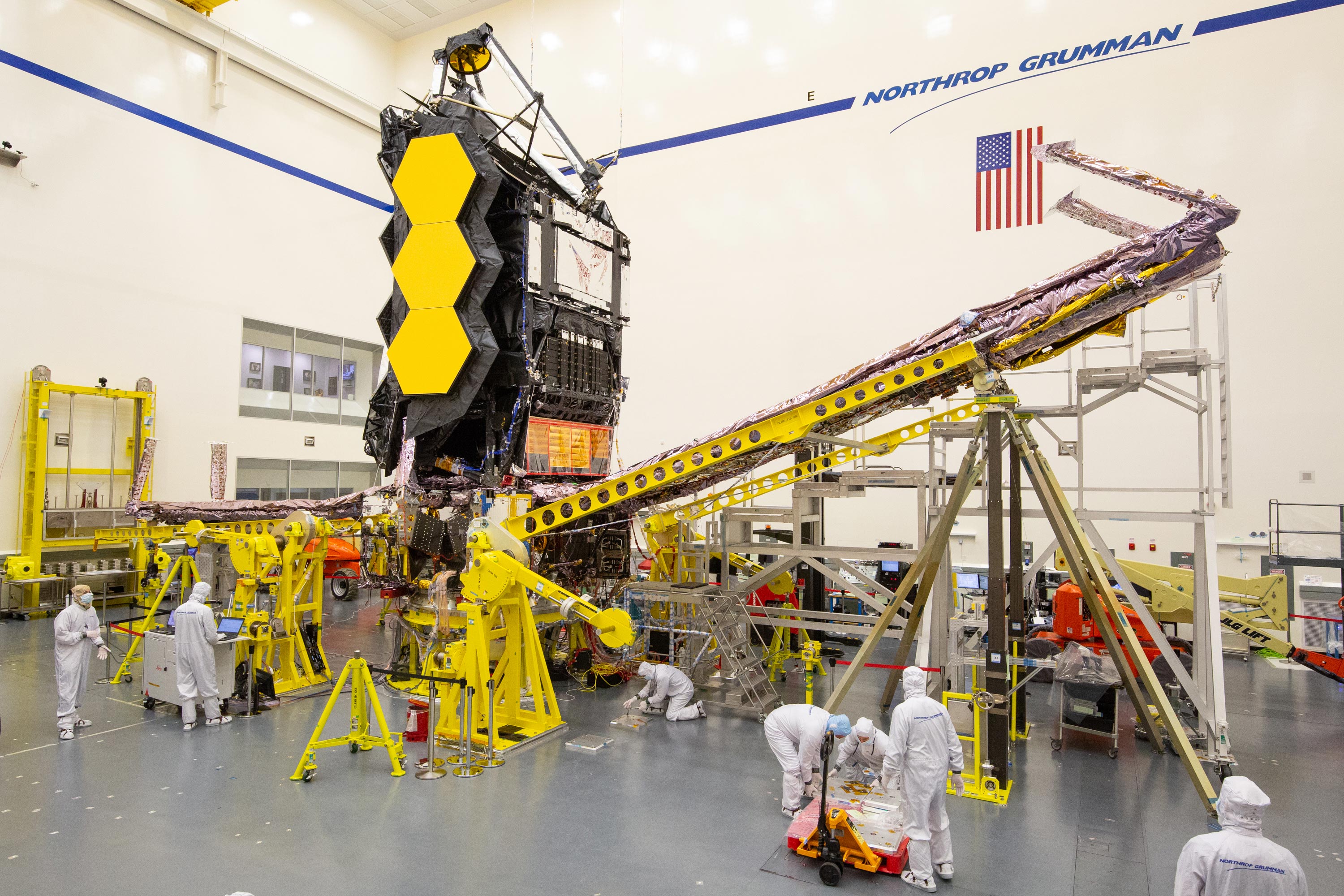 Engineers in clean suits work on the James Webb Space Telescope