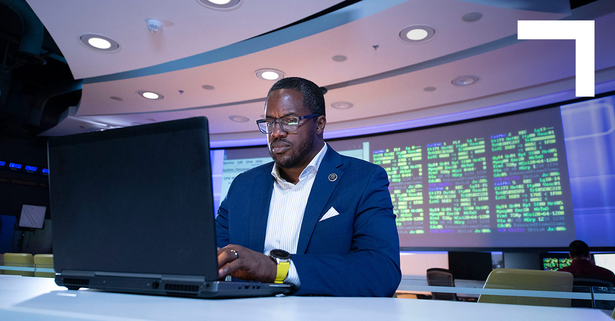 black man in suit on laptop