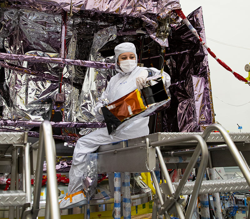 Female worker on ladder near spacecraft