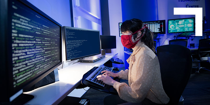 Woman wearing mask working on a computer