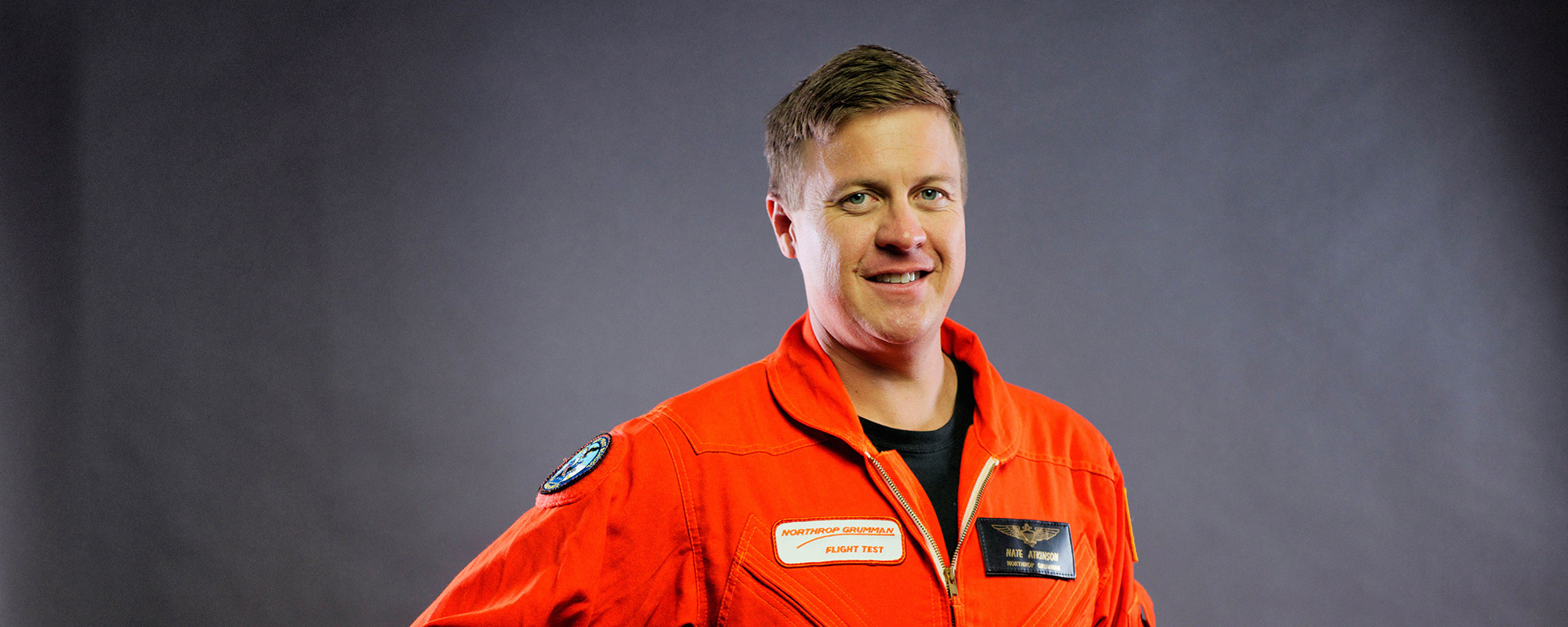 Headshot of man in orange flight suit