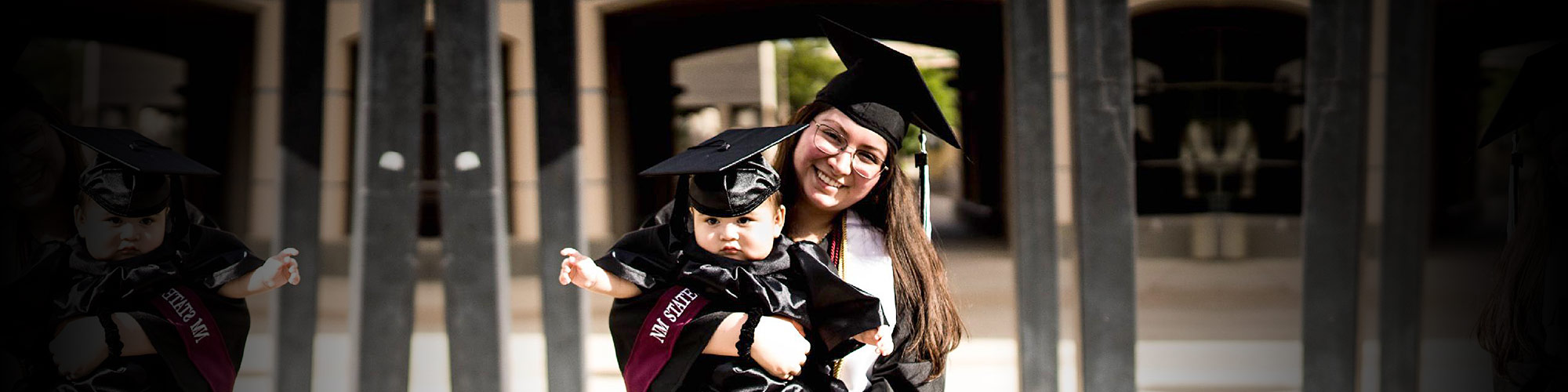 woman in cap and gown with infant on lap