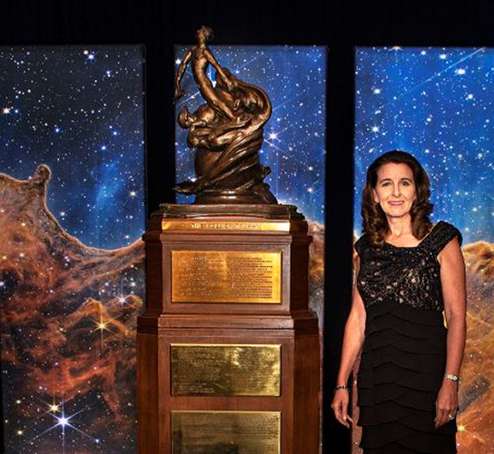 woman standing next to trophy