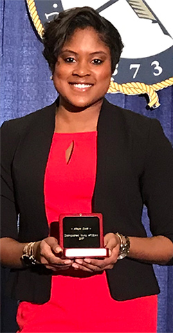 African American female smiling wile holding award