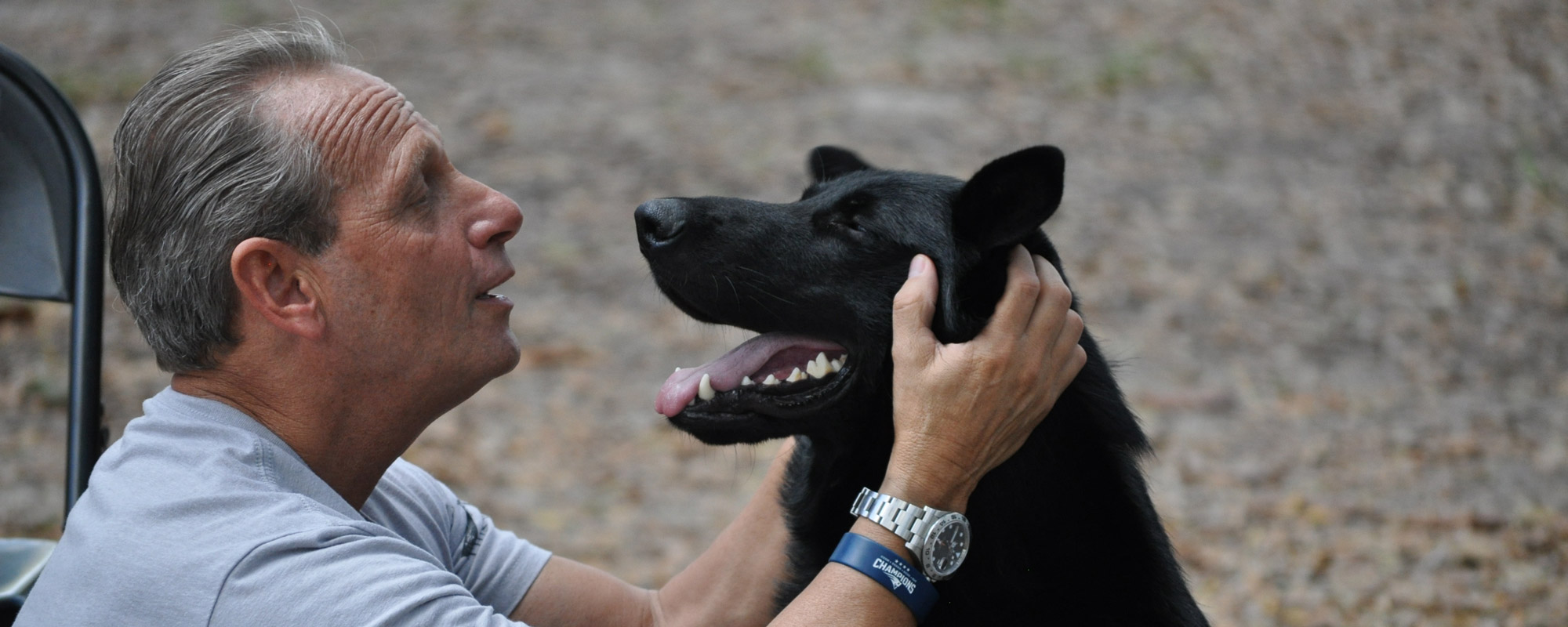 Caucasian Male Petting Black Dog