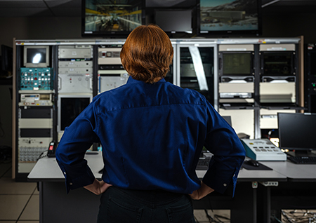 female standing in front of a computer bay
