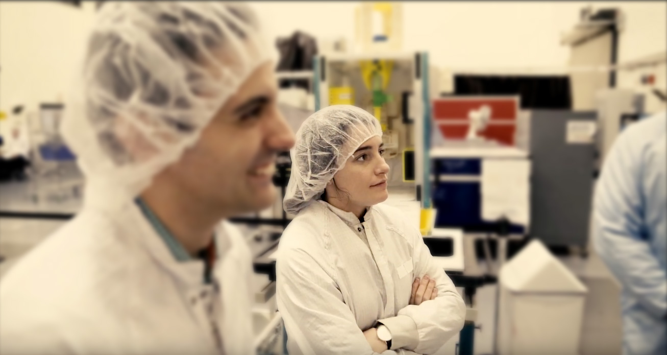 Male and female scientists in lab clothing.