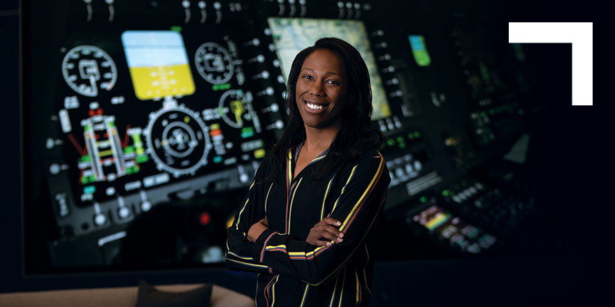 black woman smiling in front of computer monitors